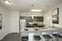 Modern kitchen with sleek granite countertops, stainless steel appliances, and stylish pendant lighting above a breakfast bar with seating.