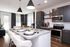 Sleek modern kitchen with stylish pendant lights, polished countertops, and elegant dining area.