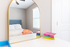Bright and inviting bedroom with a plush bed, accented by colorful decor and a stylish mirror.