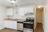 Modern kitchen with sleek stainless steel appliances, elegant white cabinetry, and warm hardwood floors.