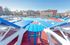 Inviting outdoor swimming pool area with stylish blue sun loungers and a vibrant atmosphere, perfect for relaxation in a modern apartment complex.