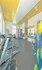 Modern apartment gym with state-of-the-art equipment, featuring bright yellow accents and natural light for an invigorating workout experience.