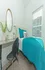 Cozy bedroom with vibrant turquoise bedding, a sleek desk, and large window for natural light.