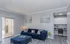 Elegant living room with a plush navy sofa, modern decor, and expansive glass doors leading to a cozy outdoor space.