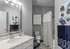 Elegant bathroom with modern fixtures, large mirror, and tasteful abstract art, creating a serene and stylish ambiance.