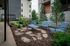 Charming outdoor seating area with modern blue benches, surrounded by lush greenery and a contemporary building backdrop.