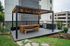 Modern apartment patio with a sleek pergola, stylish wooden dining set, and built-in BBQ, perfect for outdoor entertaining.