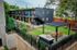 Modern apartment building with stylish facade, vibrant colors, and inviting outdoor area featuring a pergola and picnic table.