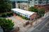Charming urban building with colorful exterior, ample parking space and lush greenery in a vibrant neighborhood.