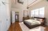 Beautiful bedroom with spacious walk-in closet, large window, and modern ceiling fan, offering natural light and elegant hardwood floors.