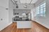 Chic modern kitchen with stainless steel appliances, stylish cabinetry, and a sleek black countertop island with warm hardwood flooring and ample natural light.