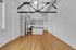 Modern kitchen with sleek stainless steel appliances, high ceilings with stylish exposed beams, and elegant chandelier lighting.