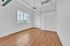 Bright, airy room with large window, sleek hardwood floors, and modern ceiling fan, offering stunning city views.