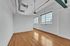 Bright and airy apartment space with sleek hardwood floors, large windows, and modern exposed ductwork.