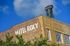 Charming vintage Hotel Roxy with classic brick facade and iconic rooftop sign under a bright blue sky.