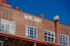 Charming historic building with 'Hotel Roxy' sign, featuring classic brick architecture and large windows against a vibrant blue sky.
