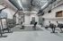 Modern gym with state-of-the-art equipment, free weights, rowing machines, and vibrant exercise balls in an industrial-style space.