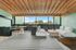 Chic outdoor patio with stylish seating under a wooden ceiling, offering a serene cityscape view.