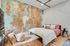 Inviting bedroom with a rustic textured accent wall, cozy pink bedding, and stylish modern furniture.