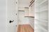 Modern walk-in closet with elegant shelving and ample hanging space in a bright, minimalist design.