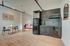 Modern studio apartment with sleek black kitchen, cozy dining area, and stylish minimalistic decor.