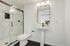 Luxurious modern bathroom with elegant marble shower, sleek pedestal sink, and contemporary lighting.