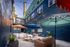 Charming courtyard with colorful umbrellas, cozy seating, and string lights creating a vibrant and inviting outdoor lounge atmosphere.