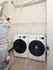 Modern laundry room featuring sleek white washer and dryer set with energy-efficient water heater, perfect for convenient home living.