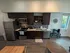 Modern kitchen with sleek dark wood cabinets, stainless steel appliances, and elegant hardwood floors, perfect for culinary enthusiasts.
