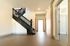 Bright and inviting hallway featuring elegant dark wood staircase, modern design, and spacious layout.