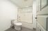 Modern bathroom with sleek glass shower enclosure and pristine white fixtures offering a refreshing ambiance.