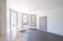 Bright open room with large windows, white walls, and a sleek gray floor, perfect for a modern living space or office.