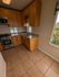 Cozy kitchen with modern stainless steel appliances and elegant wooden cabinetry, complemented by large windows offering scenic views.