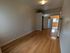 Inviting open-plan layout with elegant hardwood floors leading to a bright kitchen area, perfect for modern living.