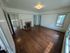Charming living room with elegant hardwood floors, a classic fireplace, and abundant natural light from large windows.