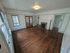 Charming living room with elegant hardwood floors, cozy fireplace, and abundant natural light from large windows.