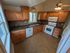 Charming kitchen with warm wooden cabinets, stainless dishwasher, and cozy tile accents, ideal for culinary creativity.