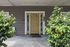 Welcoming entrance with a charming yellow front door, framed by greenery and a peaceful atmosphere.