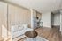 Bright modern apartment with sleek wooden flooring, compact kitchen, and cozy sofa, offering optimal space utilization and contemporary design.