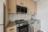 Modern kitchen featuring sleek stainless steel appliances, elegant wooden cabinetry, and stylish tile backsplash.