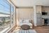 Modern apartment interior with panoramic windows, sleek kitchenette, and cozy seating area.