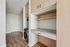 Chic hallway featuring modern built-in cabinetry with ample storage and a sleek laundry area accentuated by warm wood tones and contemporary design.