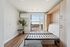 Modern bedroom with a Murphy bed, large window with scenic view, and sleek air conditioning unit.