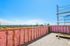 Sunny rooftop terrace under construction with panoramic views of the city, showcasing potential for outdoor living and relaxation.