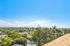 Breathtaking panoramic view of a lush, green landscape with city skyline in the distance, under a vibrant blue sky.