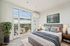 Bright, virtually staged bedroom with a large window offering scenic city views, modern decor, and cozy ambiance.