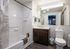 Modern bathroom with a sleek vanity, large mirror, and elegant bathtub, offering a bright and refreshing space.
