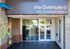 Elegant entrance of The Overture at 1812 University Avenue, showcasing modern architecture with large glass doors and stylish design.