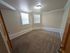 Bright and spacious bedroom with elegant molding and soft carpeted flooring, offering a warm and inviting atmosphere.