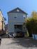 Charming modern blue building with stylish architectural details, ample driveway space, and convenient urban location.
